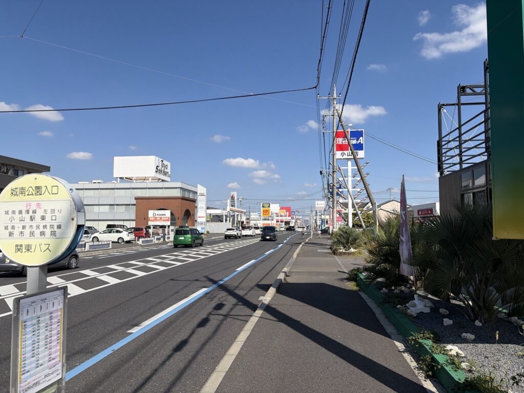 小山市城南エリアの店舗が並ぶ通りと「城南公園入口」バス停