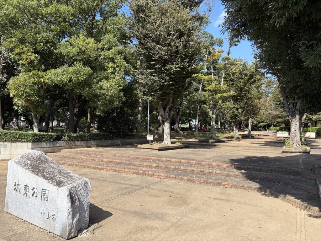 「城東公園」と刻まれた石の看板と木々に囲まれた入口